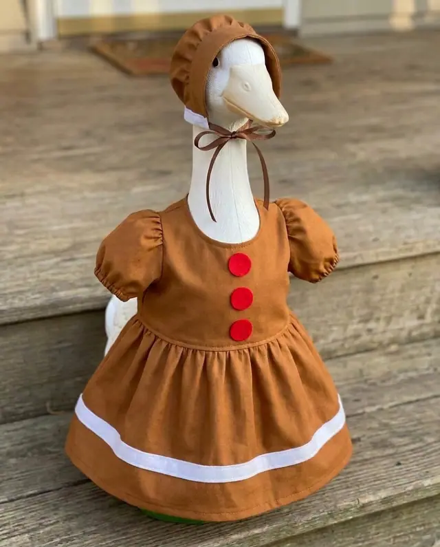 A porch goose wearing the gingerbread outfit